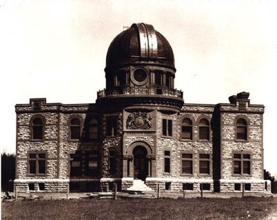 Photo in sepia of of a stone building with a metal dome at its centre