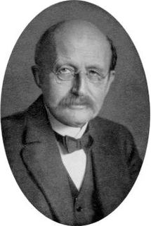 Black and white medallion photo of a man with round glasses and a mustache wearing a bow tie